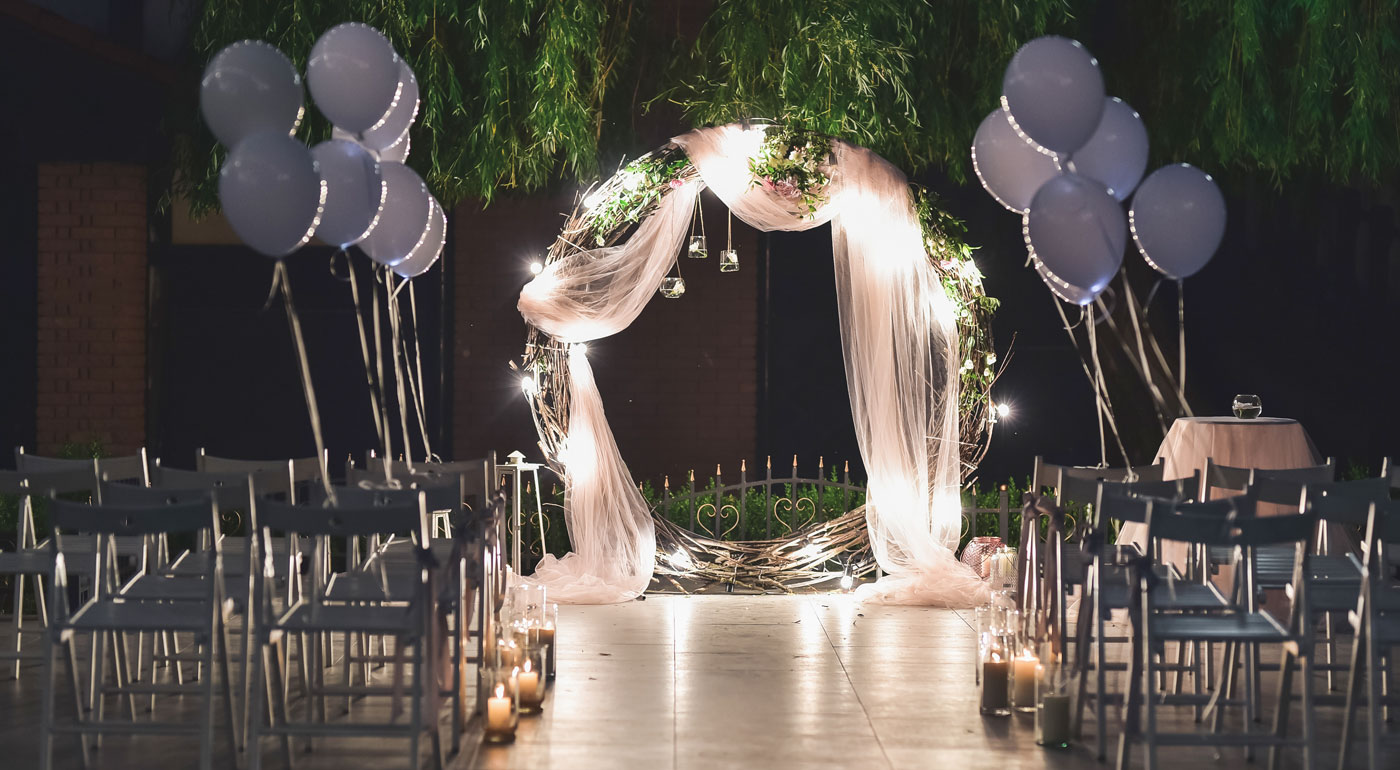 Großer Hochzeitskranz mit Luftballons und passend angeordneten Stuhlreihen.