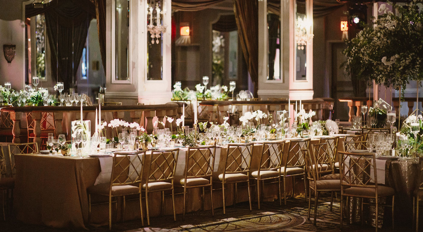 Lange Hochzeitstafel mit Tischen und Stühlen und passender Dekoration.