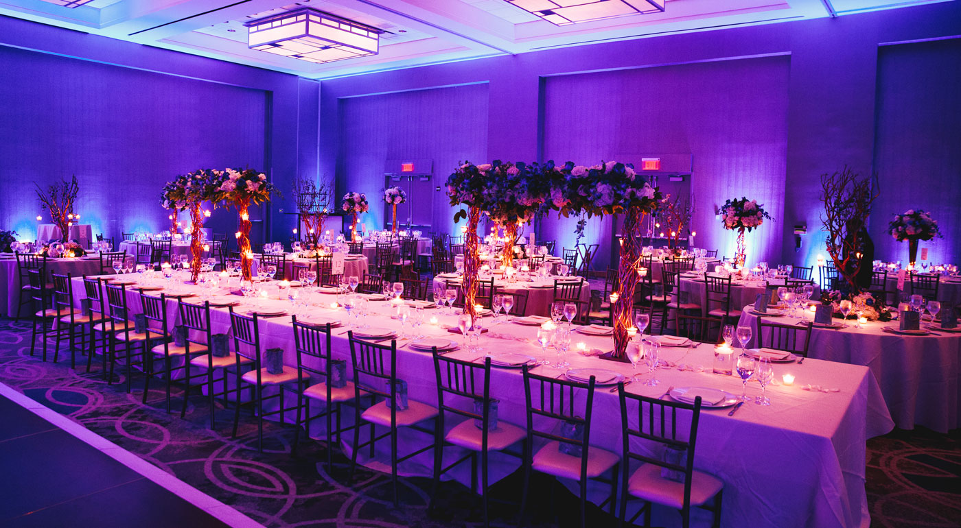 Großer Saal mit dekorierten Tischen für eine Hochzeit.